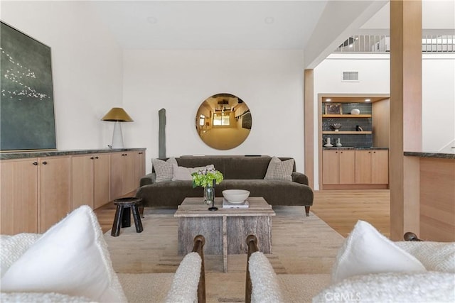 living room featuring light hardwood / wood-style flooring and built in features