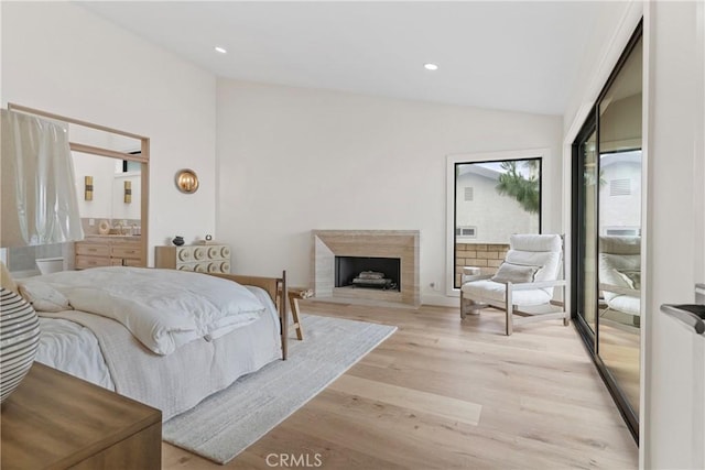 bedroom featuring lofted ceiling, access to outside, and light wood-type flooring