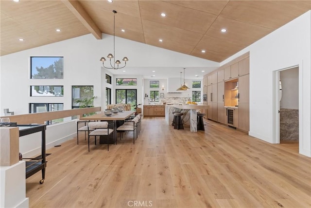 dining space with high vaulted ceiling, a notable chandelier, light hardwood / wood-style floors, wooden ceiling, and beverage cooler