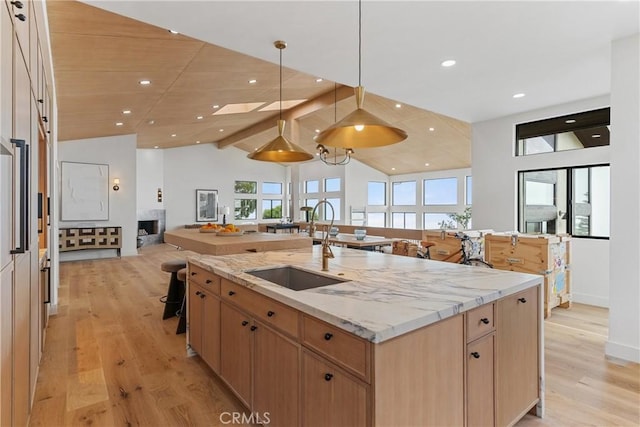 kitchen with pendant lighting, sink, lofted ceiling, and a spacious island