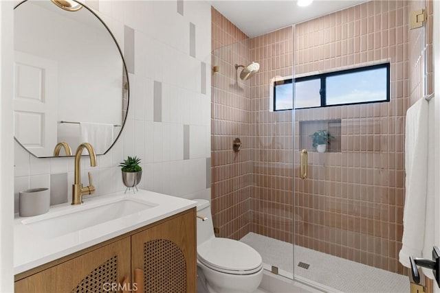 bathroom with tile walls, backsplash, vanity, toilet, and walk in shower