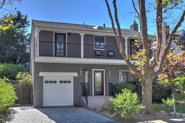 view of front of house featuring a garage and a balcony