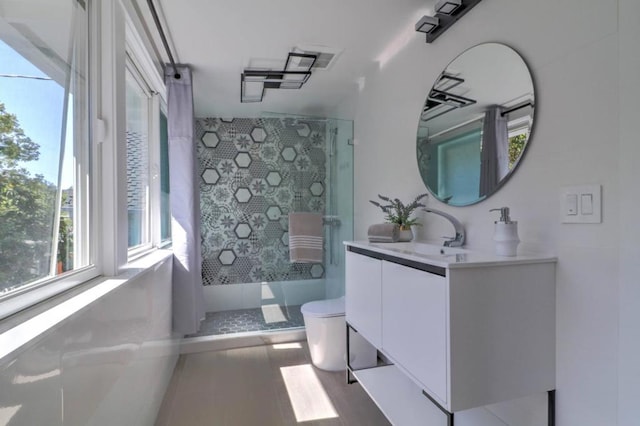 bathroom with vanity, toilet, and walk in shower