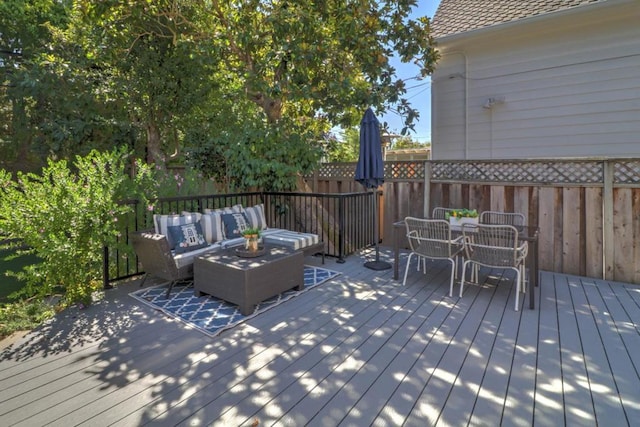 wooden terrace featuring an outdoor living space with a fire pit