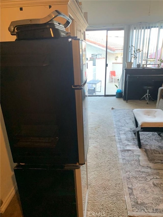 kitchen with stainless steel fridge and carpet floors