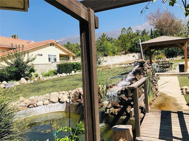 view of yard with a gazebo and a garden pond