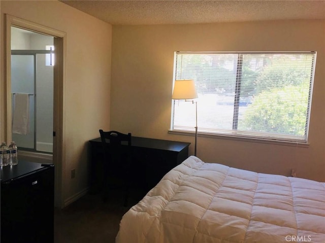 bedroom with fridge and a textured ceiling