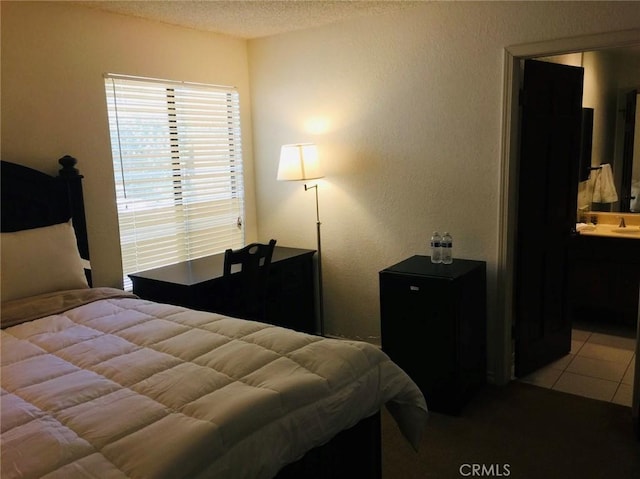 bedroom featuring light tile patterned flooring and a textured ceiling