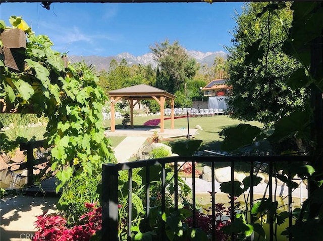 view of property's community with a gazebo, a mountain view, and a lawn