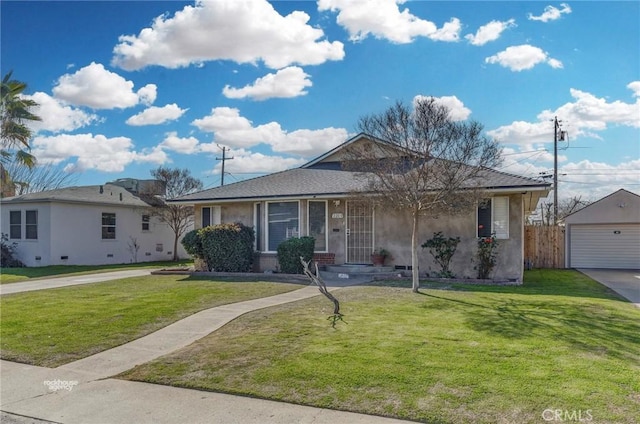 single story home with a garage, an outbuilding, and a front lawn