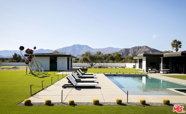 view of swimming pool featuring a patio, a mountain view, and a lawn