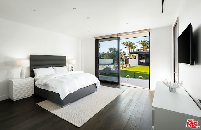 bedroom with a wall of windows, dark hardwood / wood-style floors, and access to outside