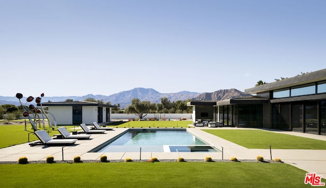 view of swimming pool with a mountain view, a yard, and a patio area