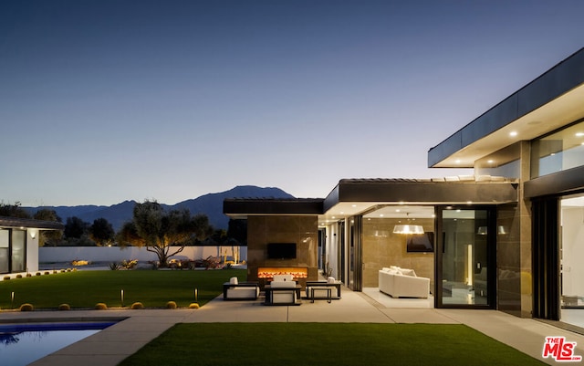 exterior space featuring an outdoor fireplace, a lawn, and a patio