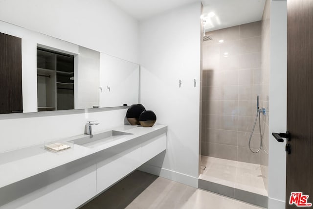 bathroom with vanity, tile patterned floors, and tiled shower