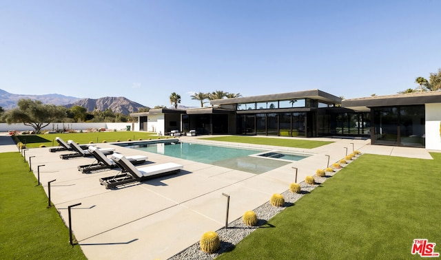 view of pool featuring a yard, a mountain view, and a patio