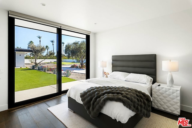 bedroom with dark wood-type flooring, access to exterior, and a wall of windows