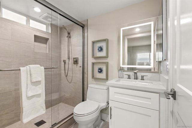 bathroom featuring vanity, an enclosed shower, and toilet