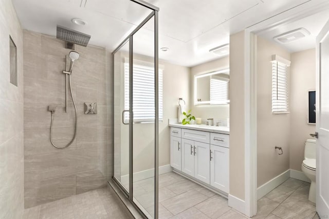 bathroom featuring vanity, toilet, tile patterned flooring, and a shower with door