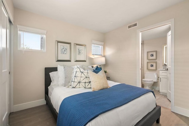 bedroom with connected bathroom and light hardwood / wood-style flooring