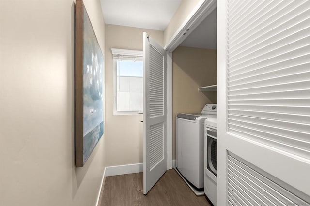 clothes washing area featuring wood-type flooring and separate washer and dryer