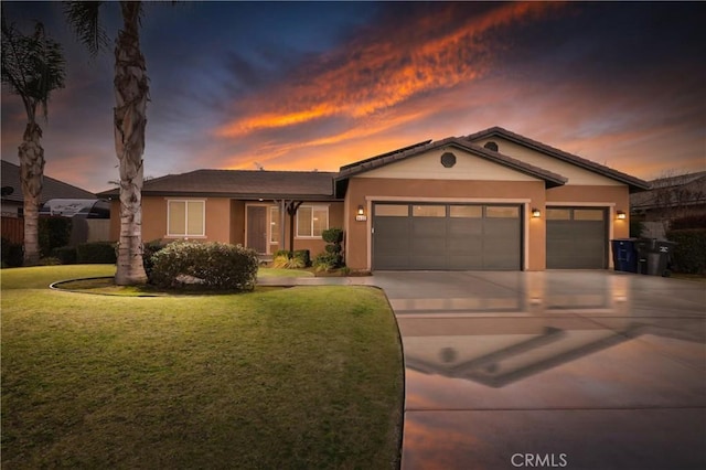 view of front of property with a garage and a yard