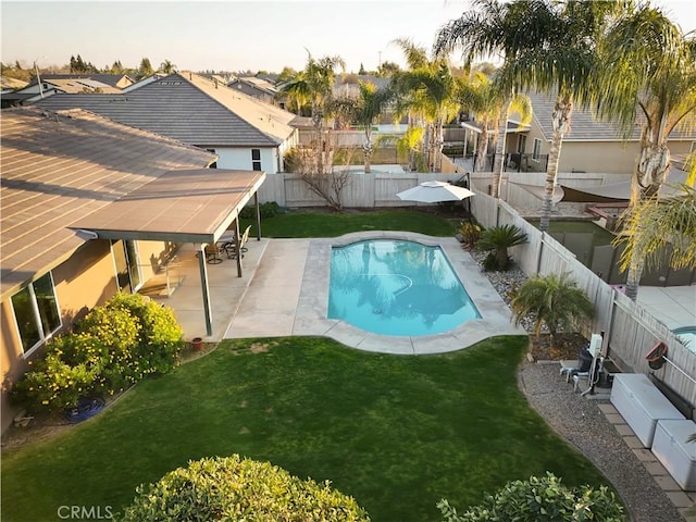 view of pool with a patio area and a lawn