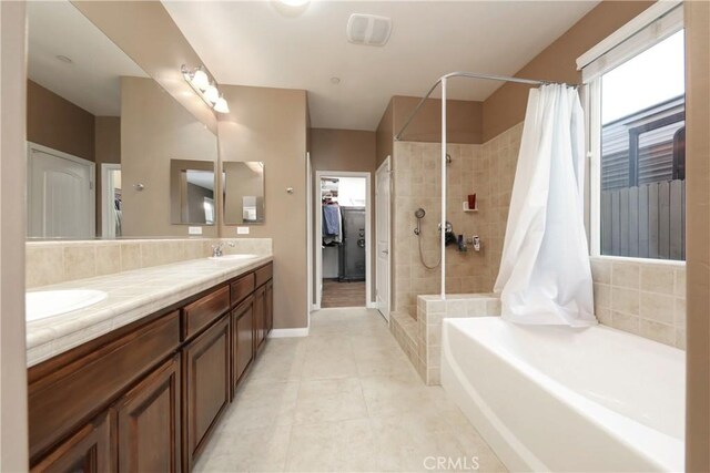 bathroom with vanity, tile patterned flooring, and plus walk in shower