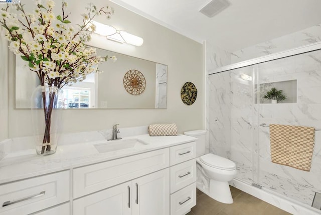 bathroom with vanity, a shower with shower door, and toilet