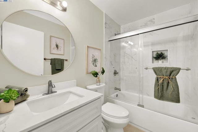 full bathroom featuring vanity, toilet, and combined bath / shower with glass door