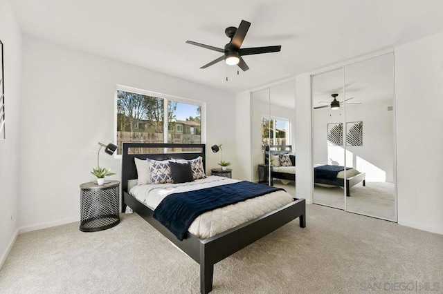 carpeted bedroom featuring two closets and ceiling fan