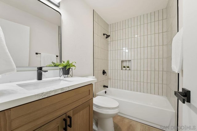 full bathroom featuring tiled shower / bath, vanity, toilet, and hardwood / wood-style floors