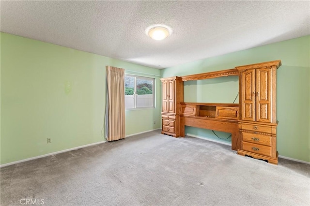 unfurnished bedroom with light colored carpet and a textured ceiling