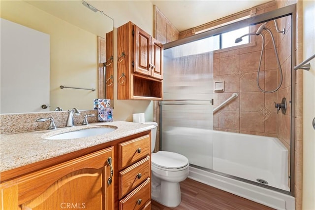 bathroom with a shower with door, vanity, hardwood / wood-style floors, and toilet