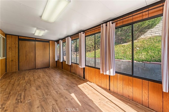 unfurnished sunroom featuring vaulted ceiling and a wealth of natural light