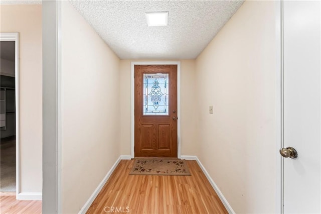 doorway to outside featuring hardwood / wood-style flooring and a textured ceiling