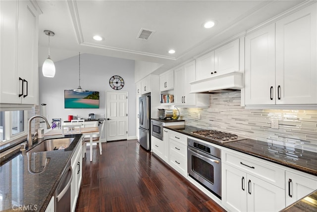 kitchen with white cabinetry, appliances with stainless steel finishes, and custom exhaust hood