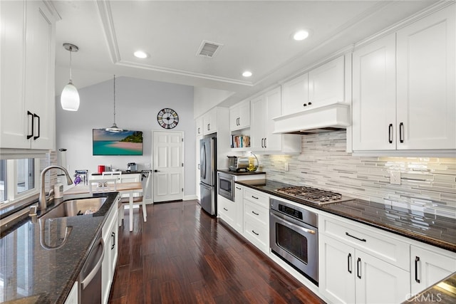 kitchen with white cabinetry, stainless steel appliances, and custom range hood