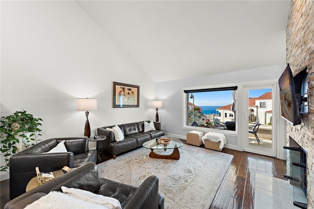 living room with a fireplace, dark hardwood / wood-style flooring, and high vaulted ceiling