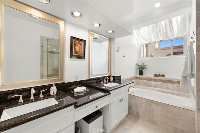 bathroom with vanity and shower with separate bathtub