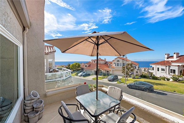 view of patio / terrace featuring a balcony and a water view