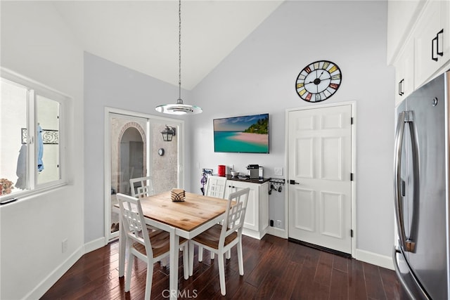 dining space with dark hardwood / wood-style floors and high vaulted ceiling