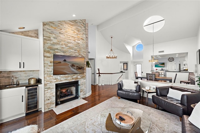 living room featuring dark hardwood / wood-style floors, sink, wine cooler, a chandelier, and beam ceiling