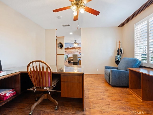 office featuring ceiling fan, ornamental molding, a healthy amount of sunlight, and light hardwood / wood-style floors