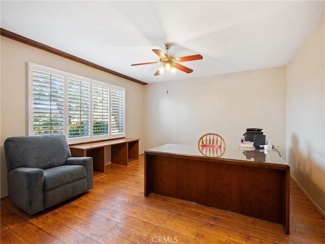 home office with crown molding, ceiling fan, and wood-type flooring