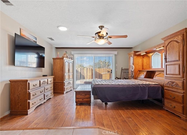 bedroom with ceiling fan, light wood-type flooring, a textured ceiling, and access to outside