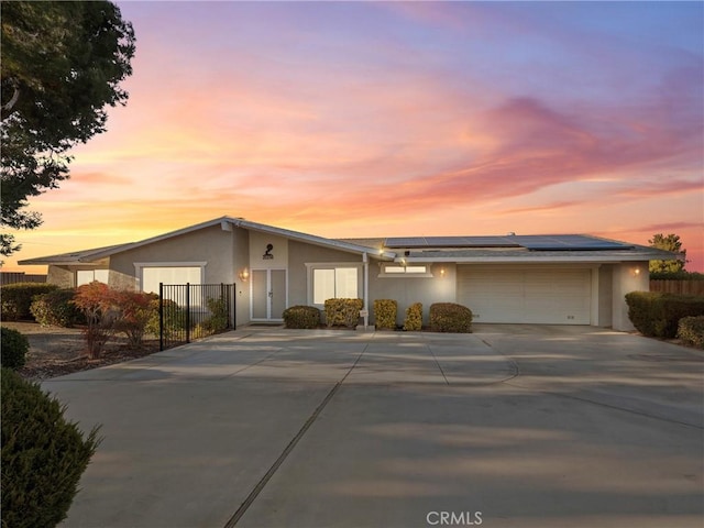 single story home featuring a garage and solar panels