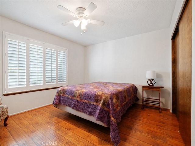 bedroom featuring wood-type flooring, a closet, and ceiling fan