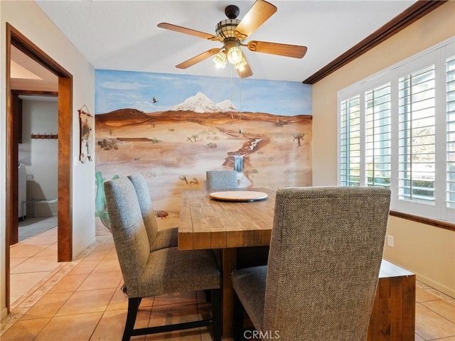 dining area with crown molding, light tile patterned floors, and ceiling fan