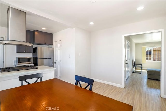 unfurnished dining area featuring baseboards, recessed lighting, and light wood-style floors